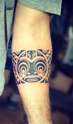  Tatouage maori, polynésien bandeau avec le tiki sur le milieu de l'avant bras